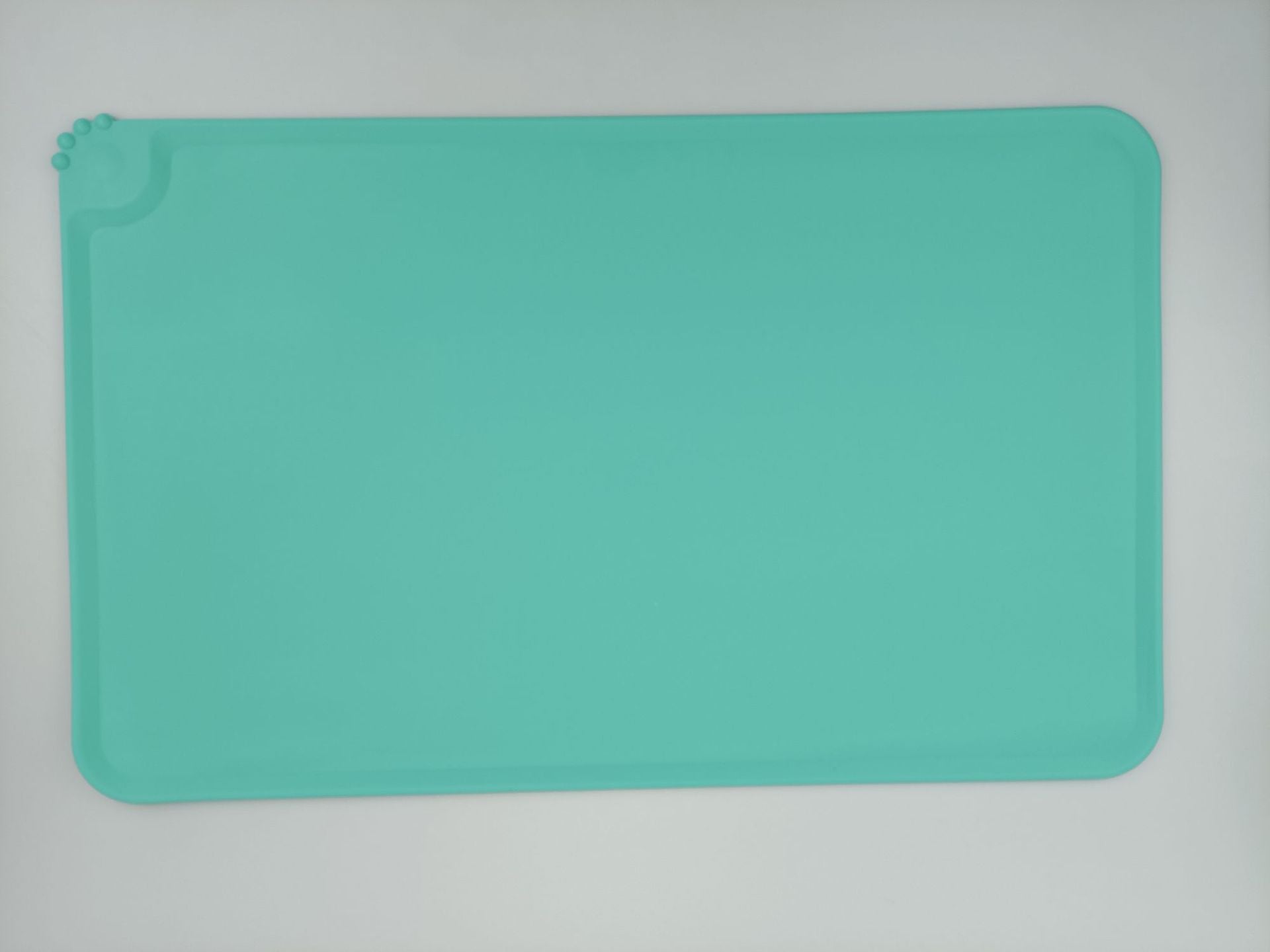 Teal silicone mat on a light gray background