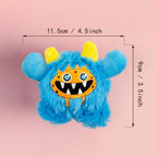 Blue plush toy with a yellow and orange face, showing measurements on a pink background