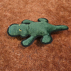 Green crocodile-shaped toy on a brown carpet surface