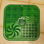 Green pet mat with paw print pattern on a tiled floor