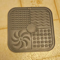 Gray silicone mat with various patterns on a tiled floor